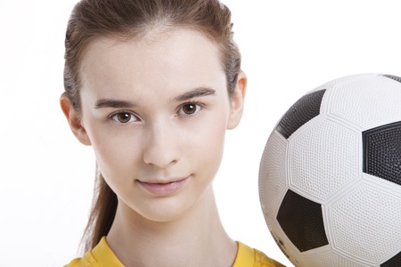 Portrait of young woman with soccer ball against white backgroundの写真素材