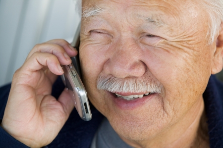 Senior man using mobile phone (close-up)の写真素材