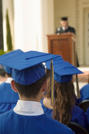 Graduates listening to speaker outside back viewの写真素材