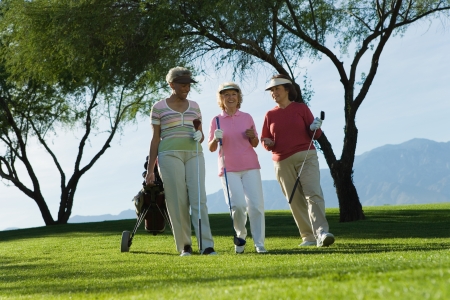 Three women walking on golf courseの写真素材