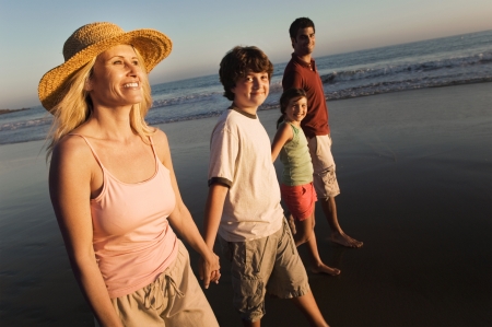 Family walking on beach at duskの写真素材