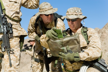 Soldiers consulting plans outdoorsの写真素材