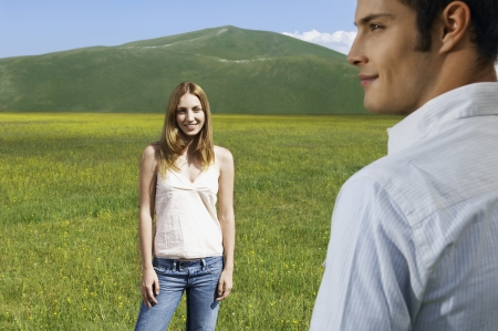 Couple in mountain Meadow woman looking at manの写真素材