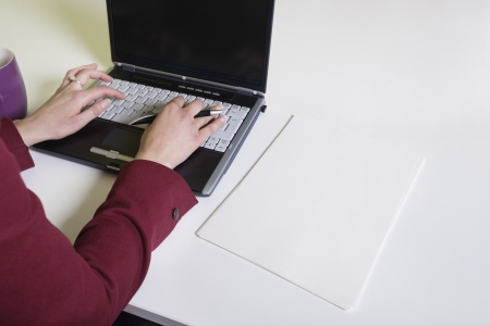 Cropped image of businesswoman's hands using laptop at deskの写真素材