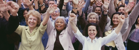 Large group of multi-ethnic people cheering with arms raised