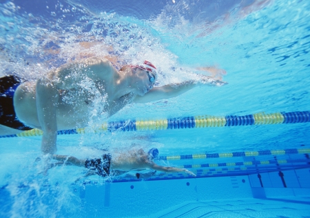 Underwater shot of three male athletes in swimming competitionの写真素材