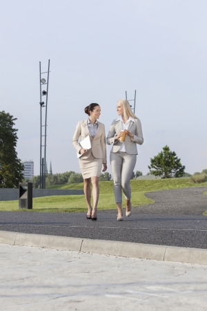 Full length of young businesswomen walking on streetの写真素材