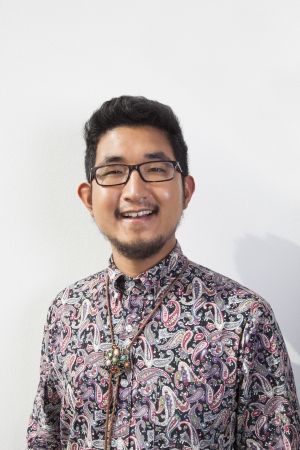 Portrait of happy young man wearing eyeglasses standing against white backgroundの写真素材