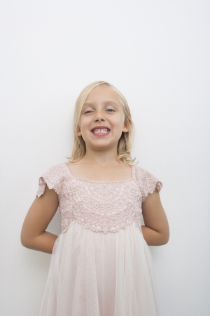 Portrait of girl smiling against white backgroundの写真素材