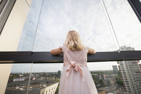 Rear view of girl looking through windowの写真素材