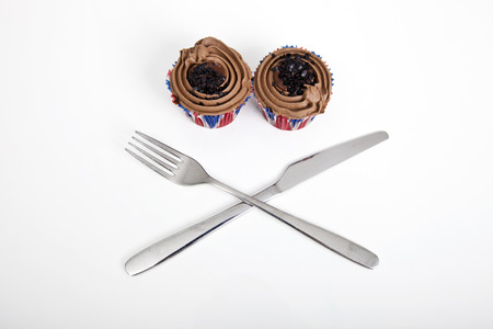 Union Jack chocolate cupcakes with fork and knife against white background