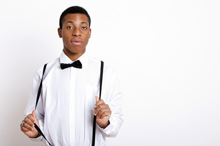 Portrait of young man wearing suspenders over white backgroundの写真素材