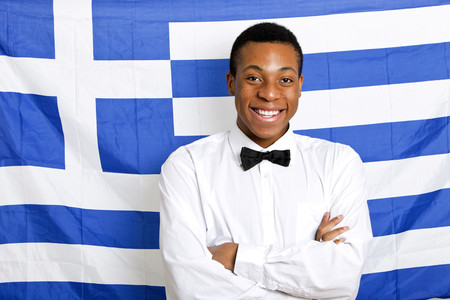 Portrait of happy man with arms crossed against Greek flagの写真素材