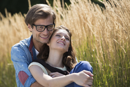 Romantic couple relaxing in fieldの写真素材