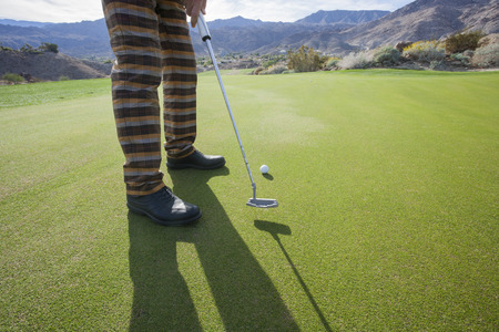 Low section of senior male golfer playing at golf course