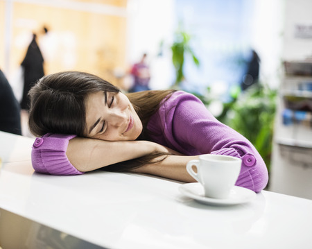Young businesswoman sleeping at desk in office