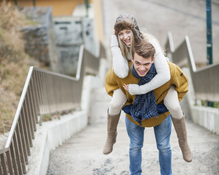 Portrait of smiling woman being piggybacked by man on stairwayの写真素材