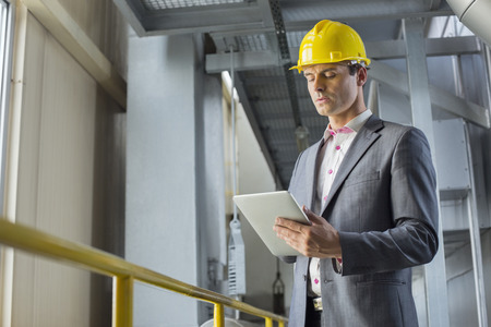 Young businessman using tablet computer in industry