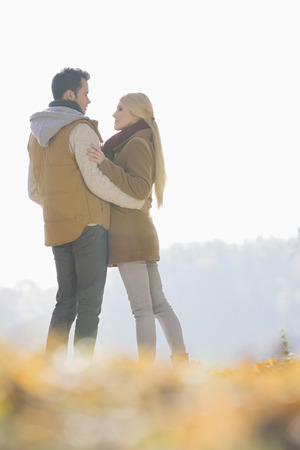 Couple hugging during autumn in parkの写真素材