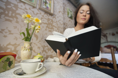Young woman reading book in cafeの写真素材
