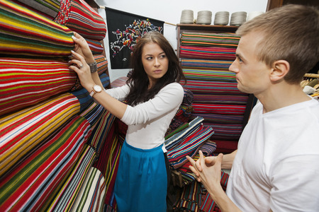 Female salesperson assisting man in textile storeの写真素材