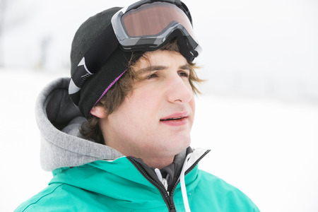 Young man wearing ski goggles outdoorsの写真素材