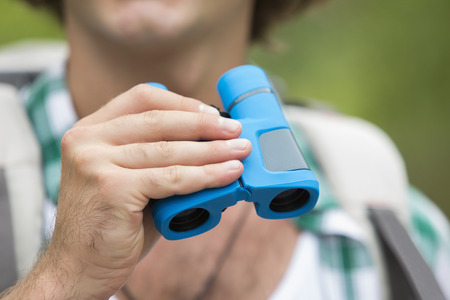 Close-up of male hiker holding binocularsの写真素材