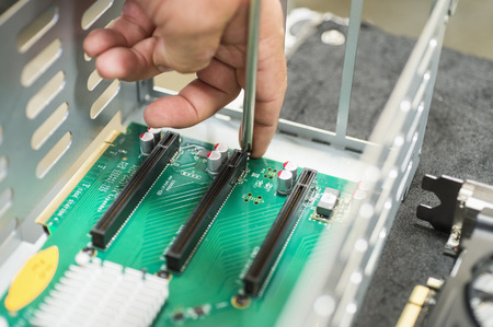Cropped image of male technician repairing PCI slots in computer factory