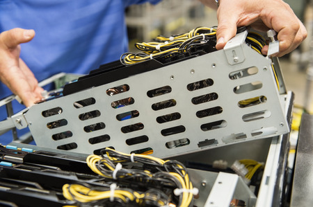 Midsection of male technician examining video card in computer manufacturing industryの写真素材