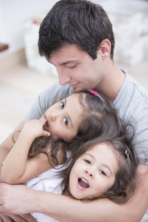 Father with daughters relaxing at homeの写真素材