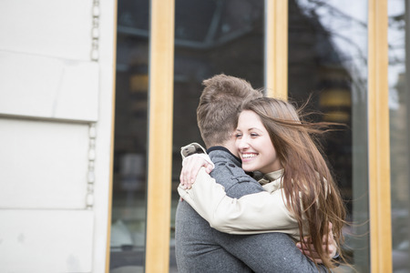 Side view of romantic couple hugging outside cafeの写真素材