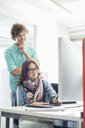 Businesspeople using desktop computer in creative officeの写真素材