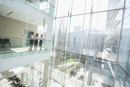 Businesswomen discussing at office balconyの写真素材