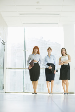 Full-length of confident businesswomen standing in officeの写真素材