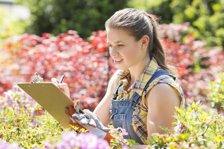 Female supervisor writing on clipboard in gardenの写真素材