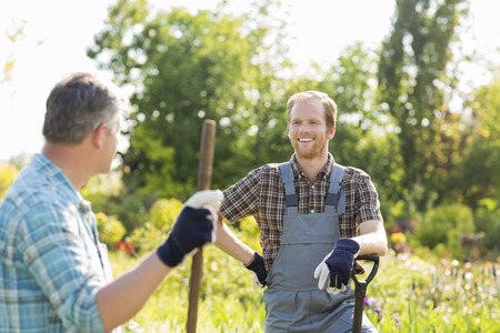 Happy gardeners talking at plant nurseryの写真素材