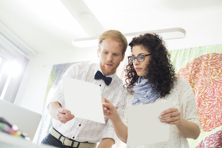 Creative business colleagues discussing over samples in officeの写真素材