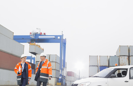 Workers conversing while walking in shipping yard