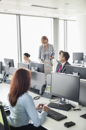 Business people working in an open plan officeの写真素材