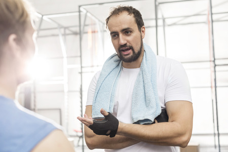 Man talking to male friend in crossfit gymの写真素材