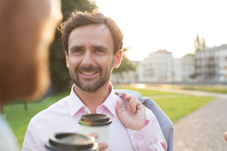 Happy businessman with colleague at park on sunny dayの写真素材