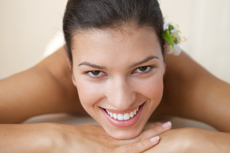Close-up of cheerful young woman relaxing on massage tableの写真素材