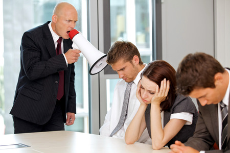 Young confident caucasian businessman screaming on his employeeの写真素材