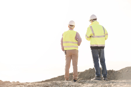 Rear view of architects standing at construction site against clear skyの写真素材