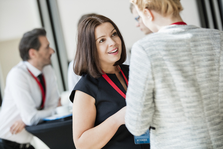 Businesswomen talking during coffee break at convention centerの写真素材