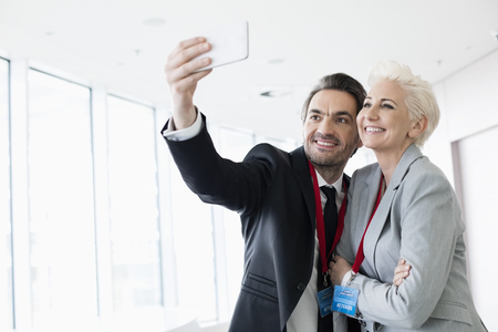 Business people taking selfie in convention centerの写真素材