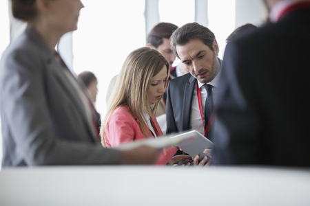 Business people using digital tablet in convention centerの写真素材