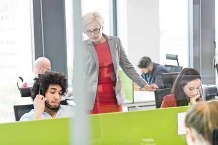 Mature female manager with operators working in office