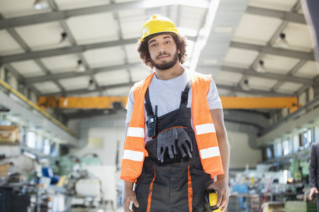 Portrait of young man wearing protective clothing in metal industryの写真素材