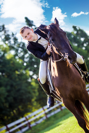 Portrait of confident man riding horse on fieldの写真素材